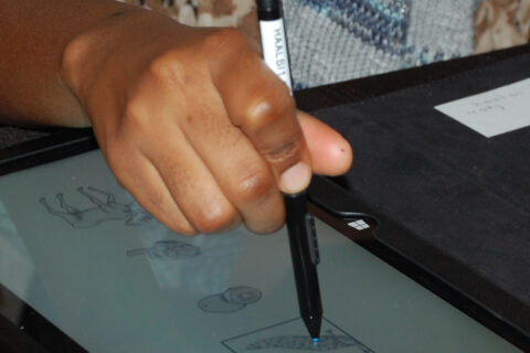 hand on a pen on a tablet